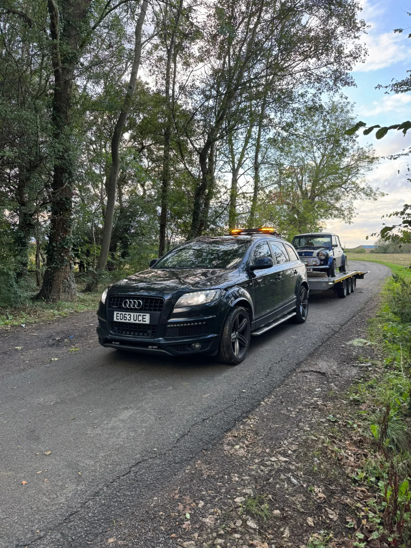 KYS Recovery tow vehicle transporting a classic Mini on a country road